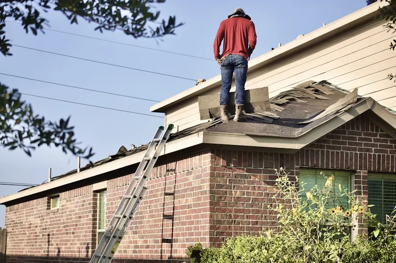 Professional roofer working on a residential roof in Stafford Springs